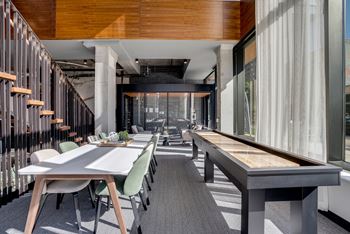 A large dining area with tables and chairs and a shuffleboard